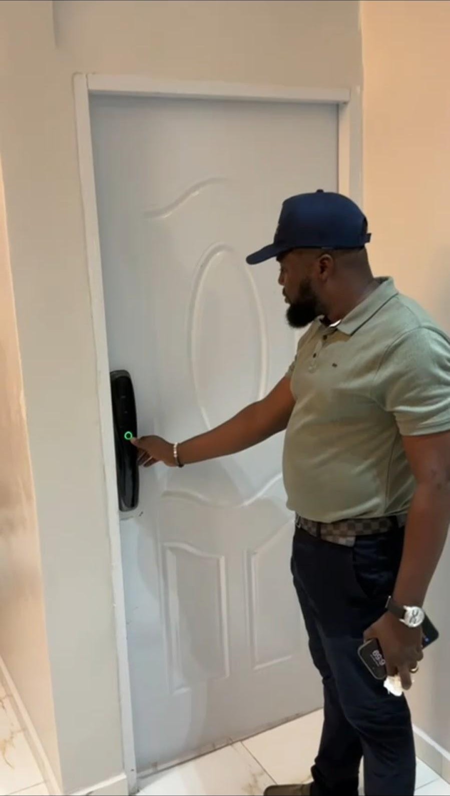 EcoBot technician demonstrating a fingerprint smart lock installed on a home in Accra